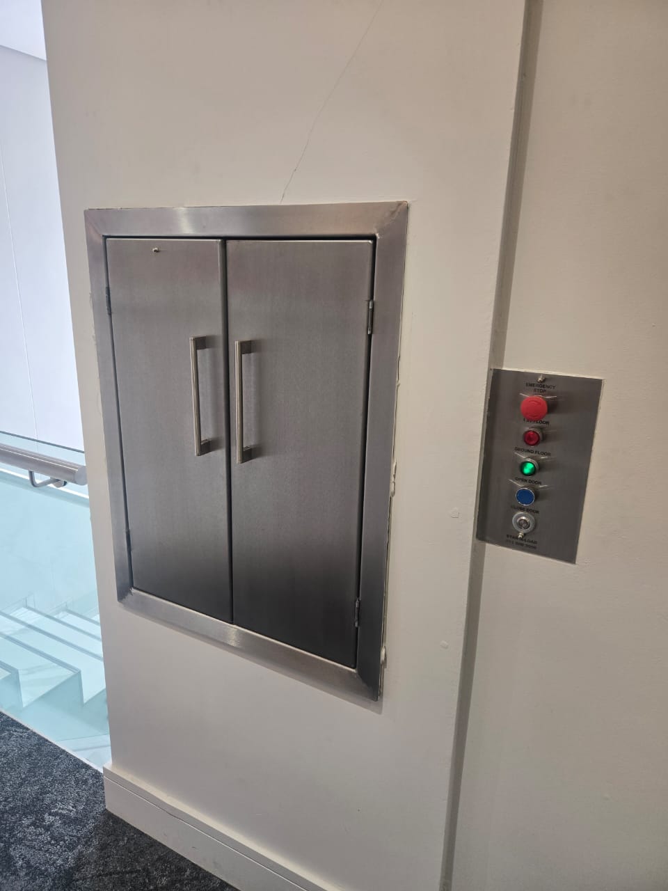 Small stainless steel dumbwaiter doors and control buttons